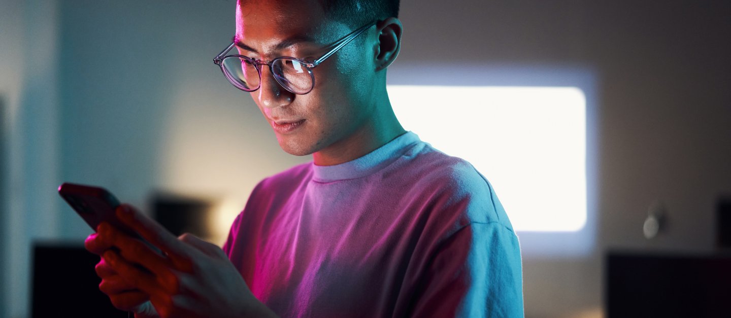 Junger Mann schaut auf sein Smartphone